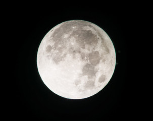 Zoomed photo of the full Moon, isolated on a black sky