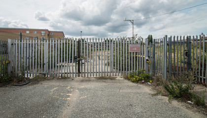 Fenced off derelict land, formally an industrial plant, UK.