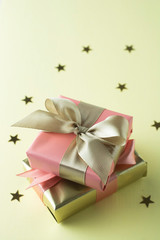 Golden and pink gift box isolated on yellow background. Birthday, Christmas party mock up.