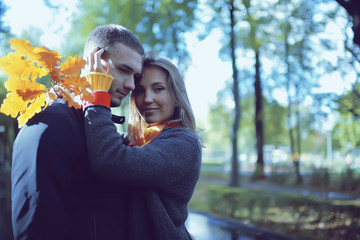 autumn landscape with people in the park / gerfrend and boyfriend hug in autumn park, fall view person