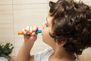 Little boy brushing his teeth in bathroom in front of mirror, oral hygiene