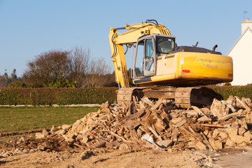Digger on a heap of rubble in a field