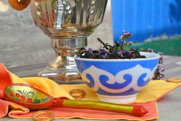 Tea drinking outdoors. Herbal tea of blooming sally and russian samovar.