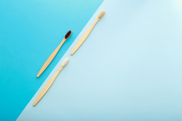 Dental care with eco friendly bamboo toothbrush on blue background top view. Zero waste and plastic free concept.
