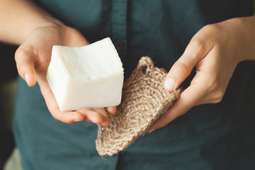 Eco-friendly cleaning kit. Organic soap and jute washcloth in the woman's hand. Zero waste concept,...