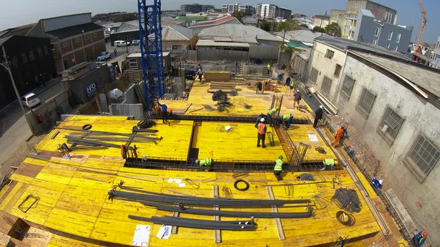 Timelapse of construction workers on the deck of a building fixing steel before the deck is poured