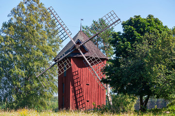 Fototapeta na wymiar Old red windmill in a summer landscape