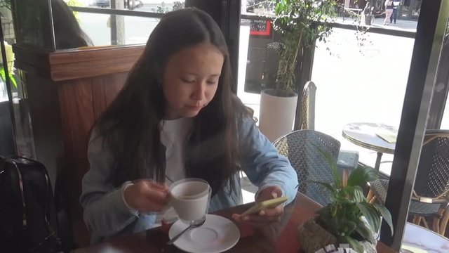 a girl drinking coffee in cafe in Paris