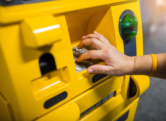 Close up of hand entering pin at an yellow ATM. Finger about to press a pin code on a pad. Security code on an yellow automated teller machine (ATM).  ATM entering pin. Selective focus.