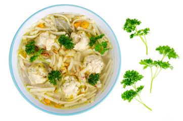 Chicken broth with egg noodles and meatballs.