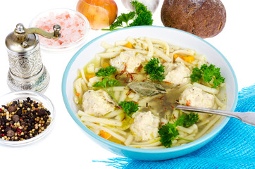 Chicken broth with egg noodles and meatballs.