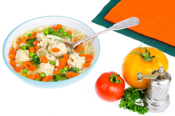 Chicken broth with vegetables, pasta and meatballs.