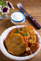 Potato pancakes with fried pork belly and onion in bowl - vertical