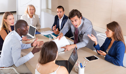 Obraz premium Man discussing emotionally with colleagues