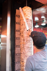 Baghdad, Iraq – July 06, 2019: An arm moving to cut the kebab meat