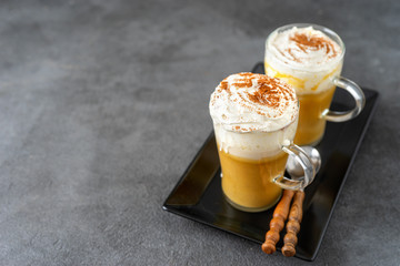 Two glass cups with spice pumpkin cappuccino