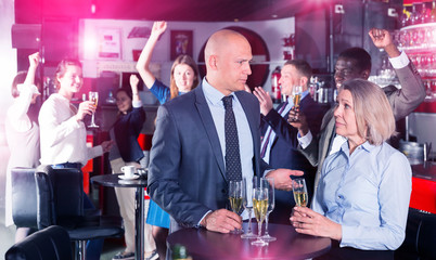Upset mature woman talking to boss on corporate party
