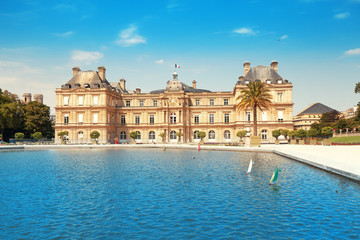 Fototapeta na wymiar 26 July 2019, Paris, France: Luxembourg Palace in The Jardin du Luxembourg. View with pond with small boats