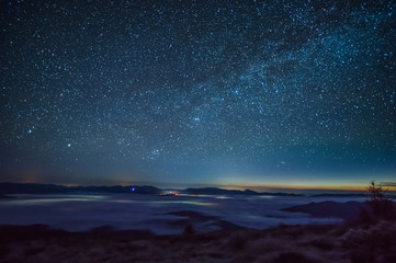 Fog in the mountains against the background of the starry sky