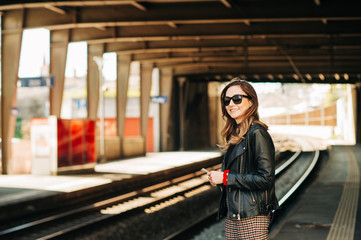 Young woman waiting for the train on a train station