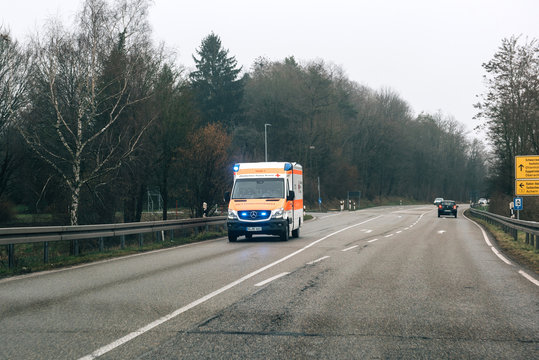 ACHERN GERMANY - FEB 18, 2018: Driver POV personal perspective toward the driving in front Deutsches Rotes Kreuz ambulance on a rainy day