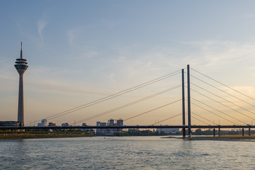 Fototapeta na wymiar Outdoor scenery of Düsseldorf City skyline, downtown, tower bridge, riverside and Rhine River, and beautiful background of golden gradient sunset sky. 