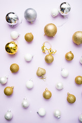 christmas balls arranged on a violet background, christmas concept and idea, golden , silver and white balls with confetti, flatly composition, christmas glitter holiday,  Xmas patter and background.