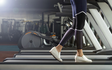 Fototapeta na wymiar Legs White Shoes of slim Fitness woman exercise warm up on running machine treadmill in Fit Gym. Concept female Can Do athlete Sport healthy, copy space