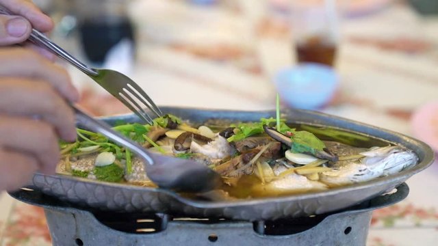 eating steamed snapper with soy sauce,slow motion movement,Thai food