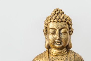 Generic golden statue of Buddha on white wall background. Interior decoration accessories abstract concept of balance zen meditation harmony. Inspirational poster with copy space