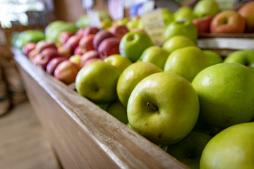 A variety of apples on display for sale at a farmer's market or fruit stand.