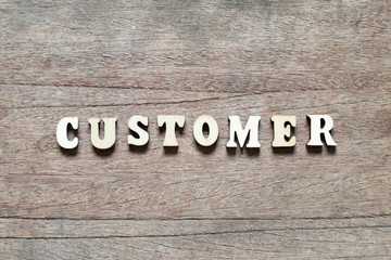 Letter block in word customer on wood background
