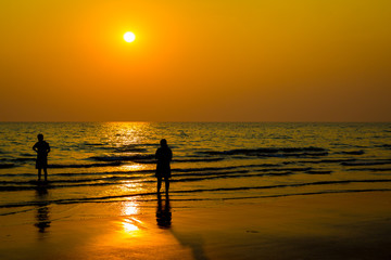 Siluate lovers and beach before sunset