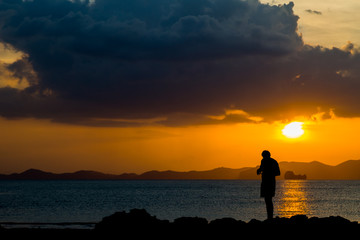 Fototapeta premium Siluate lonely man at the beach before sunset