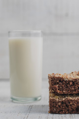 brownie en primer plano con vaso de leche detrás fuera de foco  