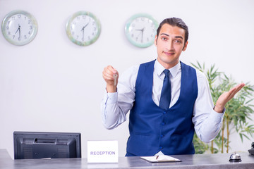 Young man receptionist at the hotel counter