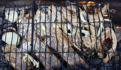 Fish on fire in barbecue. horizontal photo. Resting meal