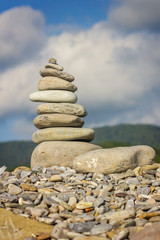 turret of stones on the beach against the blue sky