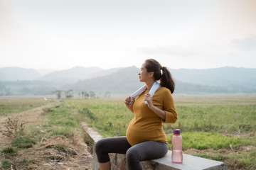 Fototapeta na wymiar maternity woman take a break after workout outdoor. pregnancy exercise
