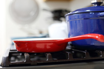 Cast iron porcelain enameled cookware on the stove top in a home kitchen.