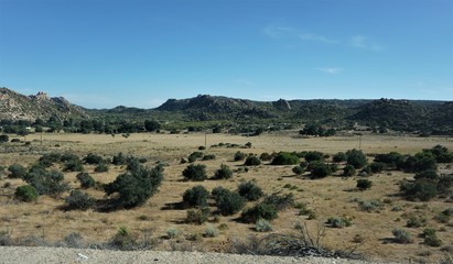 view of mountains, road in mountains, road, highway, landscape, mountain, travel, sky, mountains, desert, route, nature, way, trip, scenic, hill, grass, sand, dry, journey, outdoors, summer, clouds