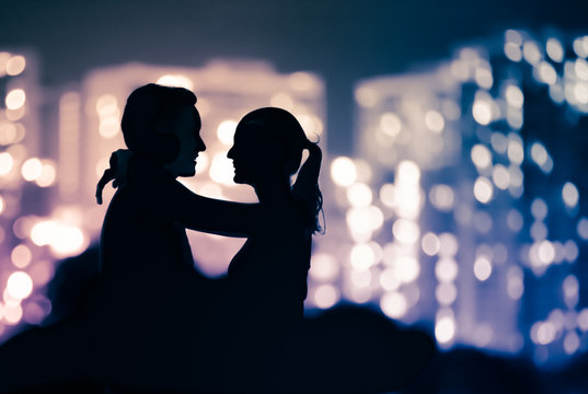 Romantic couple enjoying each others company against beautiful city lights. 