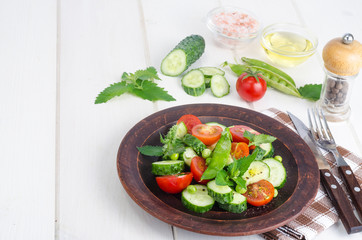 Fresh cucumber, tomato, green peas on ceramic bowl.