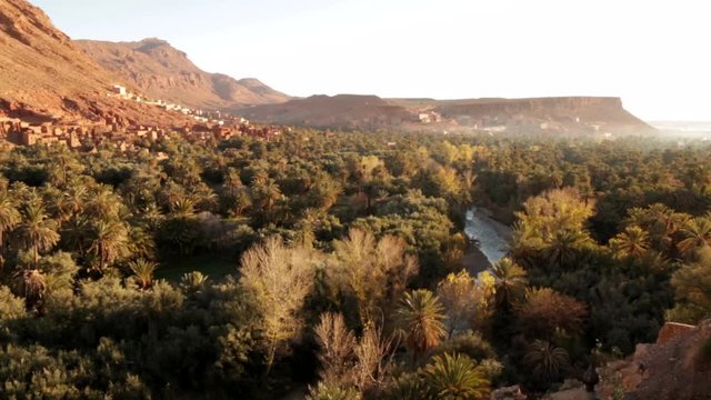 Todra gorge date grove with river running through valley and table top mountain