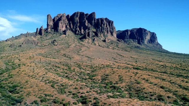 : Aerial drone shot with speed ramp revealing upwards flying towards Superstition Mountains in Apache Junction, Arizona Lost Dutchman State Park 24fps slow mo
