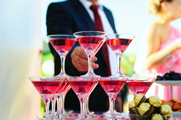 Welcome drink at the gala dinner. Glasses of pink champagne. Guests pick up martini glasses,...
