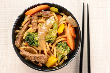 bowl with yakisoba and hashi on table