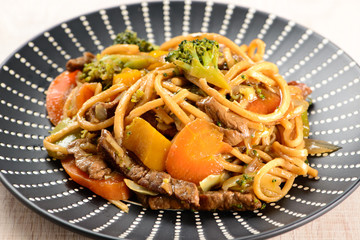 yakisoba on a black plate on a table