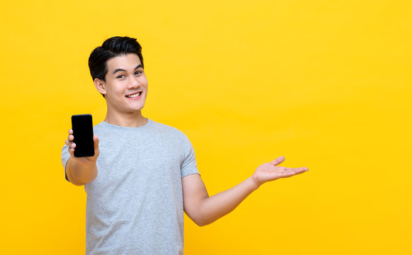 Smiling Young Asian Man Showing Mobile Phone With Another Hand Open