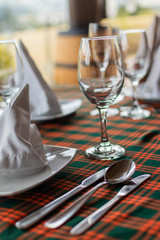 empty glass cup for wine or champagne on table decorated next to white plates for celebration on restaurant